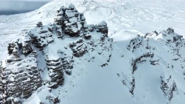 Dik tepeler buz ve karla kaplıdır ve vadiler bulutlar ve sisle örtülüdür. Yüksek kalite 4k görüntü