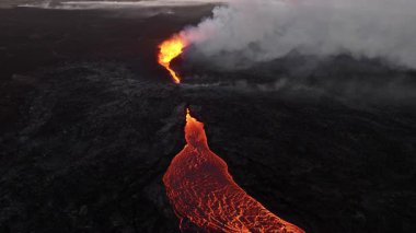 Litli-Hrutur volkanından fışkıran erimiş lav nehrinin üzerinden geçen hava aracı 2023 yılında karanlık kayaların içinden geçer. Turistlerin güzel ve tehlikeli felaketlere olan ilgisi. Yüksek kalite 4k görüntü