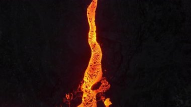 Litli-Hrutur volkanından fışkıran erimiş lav nehrinin üzerinden geçen hava aracı 2023 yılında karanlık kayaların içinden geçer. Turistlerin güzel ve tehlikeli felaketlere olan ilgisi. Yüksek kalite 4k görüntü