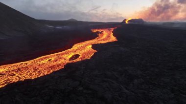 Litli-Hrutur volkanından fışkıran erimiş lav nehrinin üzerinden geçen hava aracı 2023 yılında karanlık kayaların içinden geçer. Turistlerin güzel ve tehlikeli felaketlere olan ilgisi. Yüksek kalite 4k görüntü