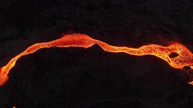 Litli-Hrutur volkanından fışkıran erimiş lav nehrinin üzerinden geçen hava aracı 2023 yılında karanlık kayaların içinden geçer. Turistlerin güzel ve tehlikeli felaketlere olan ilgisi. Yüksek kalite 4k görüntü