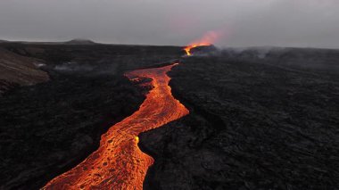 Litli-Hrutur volkanından fışkıran erimiş lav nehrinin üzerinden geçen hava aracı 2023 yılında karanlık kayaların içinden geçer. Turistlerin güzel ve tehlikeli felaketlere olan ilgisi. Yüksek kalite 4k görüntü