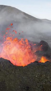 Dikey Ekran: 2023 'te volkan patlaması, İzlanda' da yerden kırmızı lav püskürmesi. Yeni aktif bir volkan oluşumu. Hava görüntüleri. Sosyal medya için çekim.