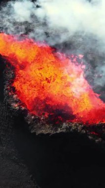 Dikey Ekran: 2023 'te volkan patlaması, İzlanda' da yerden kırmızı lav püskürmesi. Yeni aktif bir volkan oluşumu. Hava görüntüleri. Sosyal medya için çekim.