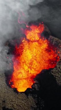 Dikey Ekran: 2023 'te volkan patlaması, İzlanda' da yerden kırmızı lav püskürmesi. Yeni aktif bir volkan oluşumu. Hava görüntüleri. Sosyal medya için çekim.