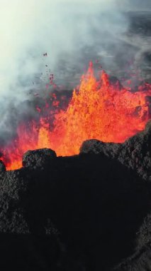 Dikey Ekran: 2023 'te volkan patlaması, İzlanda' da yerden kırmızı lav püskürmesi. Yeni aktif bir volkan oluşumu. Hava görüntüleri. Sosyal medya için çekim.