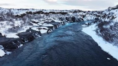 İzlanda 'da Nehir, Karlı Tepeler ve Kışın Şelaleler, Dev Akıntılı Büyülü Mavi Buzul Suyu. Hraunfossar. Yüksek kalite 4k görüntü