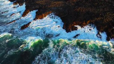 Gün batımında engebeli sahil şeridinde dalgaların nefes kesen görüntüsü güzellikleri gözler önüne seriyor..