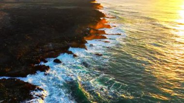 Gün batımında engebeli sahil şeridinde dalgaların nefes kesen görüntüsü güzellikleri gözler önüne seriyor..