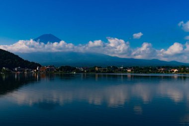 Fuji Dağı 'nın güzel görüntüsü Kawaguchi Gölü' nü vurdu. Su çok yansıtıcıdır. Dağda süzülen bulutlar bunu sihirli bir görüntü gibi gösteriyor. Bu Fujiyoshida Japonya 'da çekildi..