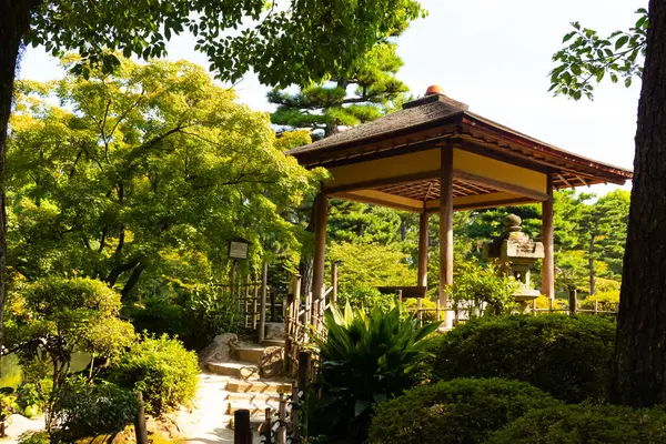Japonya 'daki parkın güzel manzarası. Güzel pagoda görüntünün kenarında duran yapıya benziyor. Huzurlu bir çevreyi gösteren meditasyon yapan yeşil yapraklar..