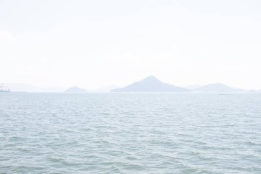 Bu Hiroşima Körfezi 'nin bir görüntüsü. Dalgalar, tuzlu suyun dalgalı tepelere ulaşmasıyla güzel ve sakin görünüyor. Güzel mavi Japon gökyüzünün içinde beyaz bulutlar var..