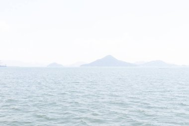 Bu Hiroşima Körfezi 'nin bir görüntüsü. Dalgalar, tuzlu suyun dalgalı tepelere ulaşmasıyla güzel ve sakin görünüyor. Güzel mavi Japon gökyüzünün içinde beyaz bulutlar var..