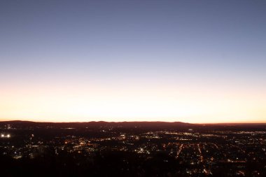 Evleri ve caddeleri olan bir vadinin çok güzel bir görüntüsü. Güneşin tüm nesneleri öptüğü son anın altın parıltısı. Güneş gün batıyor..