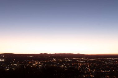 Evleri ve caddeleri olan bir vadinin çok güzel bir görüntüsü. Güneşin tüm nesneleri öptüğü son anın altın parıltısı. Güneş gün batıyor..