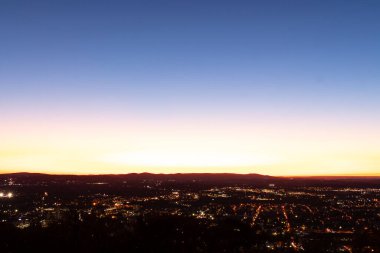 Evleri ve caddeleri olan bir vadinin çok güzel bir görüntüsü. Güneşin tüm nesneleri öptüğü son anın altın parıltısı. Güneş gün batıyor..