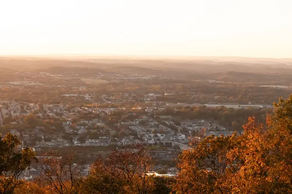 Evleri ve caddeleri olan bir vadinin çok güzel bir görüntüsü. Güneşin tüm nesneleri öptüğü son anın altın parıltısı. Güneş gün batıyor..