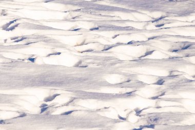 Dalgalanan kar yığınları gölgeler ve röflelerle dokulu, soyut bir manzara yaratır. Kış temaları, arka planlar veya doğal desenler için mükemmeldir..