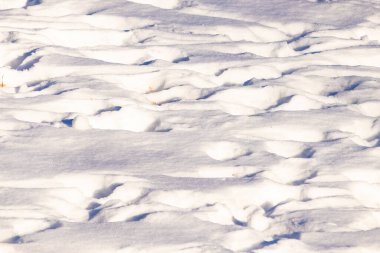 Dalgalanan kar yığınları gölgeler ve röflelerle dokulu, soyut bir manzara yaratır. Kış temaları, arka planlar veya doğal desenler için mükemmeldir..