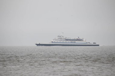Bu Cape May Lewes perisinin körfez boyunca seyahat edişinin bir görüntüsü. Bu görüntü Cape May New Jersey 'deki Sunset Sahili' nden. Büyük gemi sakin suyun üzerinden sessizce geçiyor..
