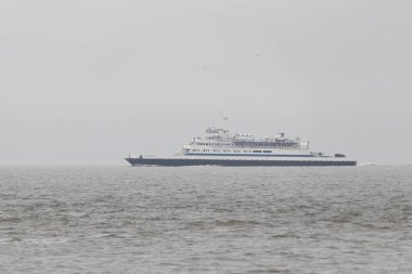 Bu Cape May Lewes perisinin körfez boyunca seyahat edişinin bir görüntüsü. Bu görüntü Cape May New Jersey 'deki Sunset Sahili' nden. Büyük gemi sakin suyun üzerinden sessizce geçiyor..