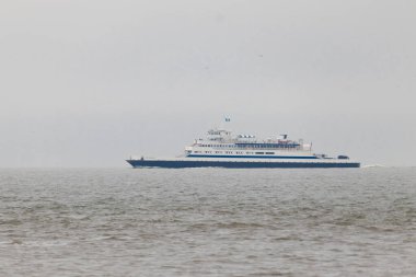 Bu Cape May Lewes perisinin körfez boyunca seyahat edişinin bir görüntüsü. Bu görüntü Cape May New Jersey 'deki Sunset Sahili' nden. Büyük gemi sakin suyun üzerinden sessizce geçiyor..