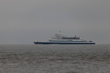 Bu Cape May Lewes perisinin körfez boyunca seyahat edişinin bir görüntüsü. Bu görüntü Cape May New Jersey 'deki Sunset Sahili' nden. Büyük gemi sakin suyun üzerinden sessizce geçiyor..