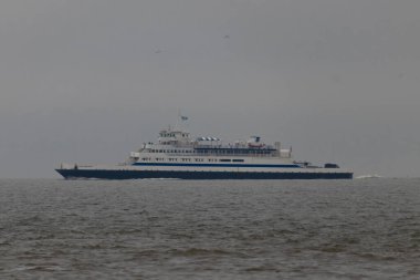 Bu Cape May Lewes perisinin körfez boyunca seyahat edişinin bir görüntüsü. Bu görüntü Cape May New Jersey 'deki Sunset Sahili' nden. Büyük gemi sakin suyun üzerinden sessizce geçiyor..