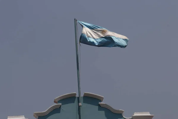 アルゼンチンの国旗が灰色の空に向かって手を振っている 高品質の写真 — ストック写真