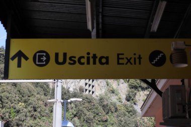 Corniglia tren istasyonunda siyah harflerle İtalyanca çıkış tabelası yüksek kalite fotoğraf.