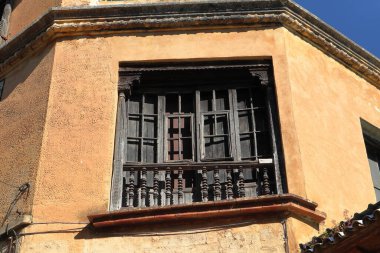 Ahşap pencereli, küçük balkonlu ve metal parmaklıklı eski bir ev parçası. Beyaz duvarlı klasik İspanyol mimarisi, Ronda, İspanya. Yüksek kalite fotoğraf