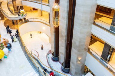 Seoul, South Korea - 12 18 2022 : Interior view of Lotte Hotel Jamsil. Large building with a spiral staircase and a statue of an angel. People are walking around the building clipart