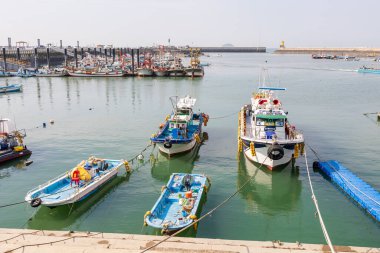 Gyeonggi-do, Güney Kore - 07 Kasım 2022 Gungpyeong Limanı, bir grup tekne rıhtıma yanaştı. Teknelerin boyutları ve renkleri farklı.