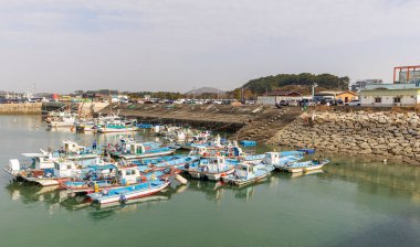 Gyeonggi-do, South Korea - November 07, 2022 : Gungpyeong Port, Group of boats are docked at a pier. The boats are of different sizes and colors clipart