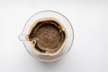 İçinde filtre olan bir bardak kahve. Kahve kahverengi ve köpüklü.