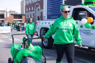 Scranton, Pennsylvania - 8 Mart 2025 St. Patrick Geçit Töreni 'nde insanlar köpeklerini sokakta gezdiriyorlar. Üzerinde 