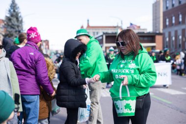 Scranton, PA - 8 Mart 2025: St. Patrick Geçit Töreni sırasında, yeşil giyinmiş insanlar yürüyor ve şeker ve hediyelik eşya dağıtıyorlar..