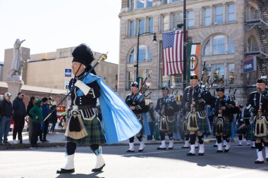 Scranton, PA - 8 Mart 2025: İrlandalı kostümlü bir grup insan caddede yürüyor, St. Patrick Geçit Töreni 'nde müzik aletleri çalıyorlar.