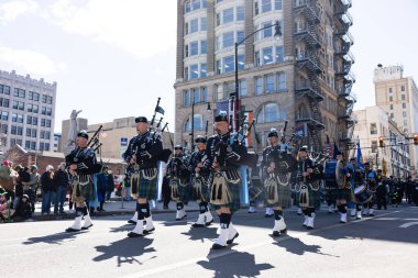 Scranton, PA - 8 Mart 2025 St. Patrick 's Parade, İskoç eteği giymiş bir grup insan caddede yürüyor. Gayda ve davul çalıyorlar.