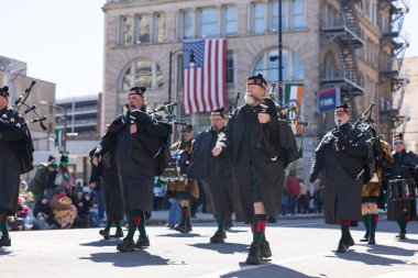 Scranton, PA - 8 Mart 2025: İrlandalı kostümlü bir grup insan caddede yürüyor, St. Patrick Geçit Töreni 'nde müzik aletleri çalıyorlar.