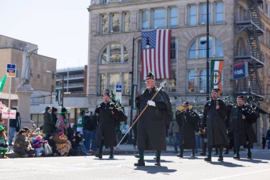 Scranton, PA - 8 Mart 2025: İrlandalı kostümlü bir grup insan caddede yürüyor, St. Patrick Geçit Töreni 'nde müzik aletleri çalıyorlar.