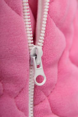 Lightning on soft pink clothes with a white lock. Close-up. Detail of clothing. Overalls.
