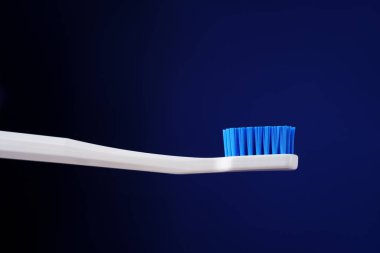 Dişçi kralı konsepti. Hijyen. Reklam afişi. Koyu mavi bir arkaplanda beyaz diş fırçası. 