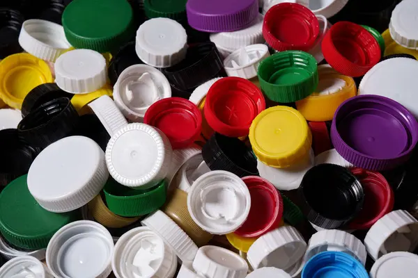 Bir sürü renkli plastik şişe kapağı. Plastik geri dönüşümü.