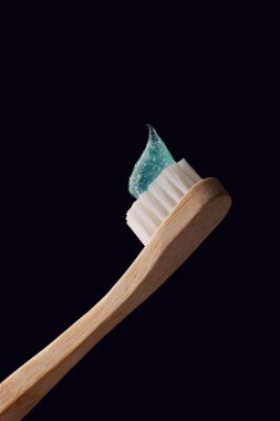 Mavi arka planda şeffaf mavi diş macunu olan bambu diş fırçası. Oral sağlık.