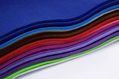 Beyaz arka planda renkli, çok renkli bir his var. Yumuşak kumaş örnekleri. El salla. Yakın plan. Tasarım projeleri için, tekstil modellemeleri, dikiş ve zanaat malzemeleri veya web ve yazdırma için renkli bir arkaplan olarak.