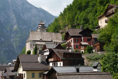 Alplerin kollarında bir dağ köyü. Bir sürü ev ve bir tapınak. Hallstatt.