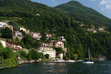 Zürih 'te bir sokakta bulunan İsviçre bayrakları alçı pervazları ve altın bir aslan figürüyle süslenmiş dekoratif defne penceresi olan bir evin pembe cephesine doğru dalgalanıyor..