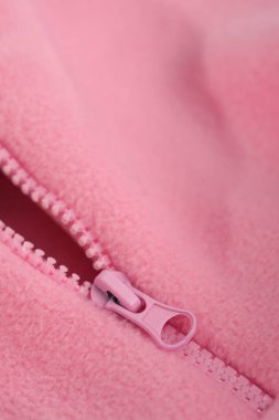 Metal zipper on pink fleece fabric. Clothing macro.