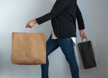 Alışveriş çantasıyla yürüyen bir insanın bacakları.